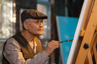 一位老年艺术家在工作室创作