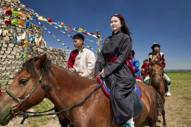 草原那达慕大会上骑着马的蒙古演员