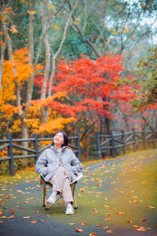 中国女性在浙江宁波奉化溪口杜鹃谷欣赏红枫