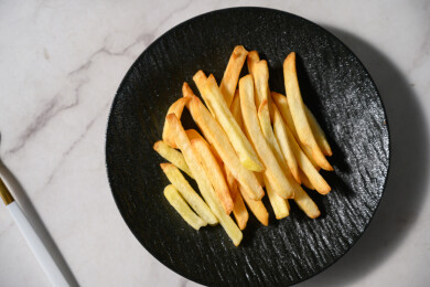 桌面上的盘子里的美味可口的薯条