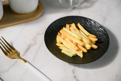 桌面上的盘子里的美味可口的薯条