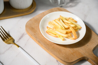 桌面上的盘子里的美味可口的薯条