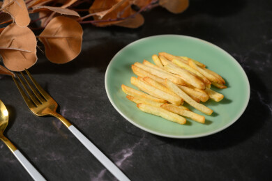 桌面上的盘子里的美味可口的薯条