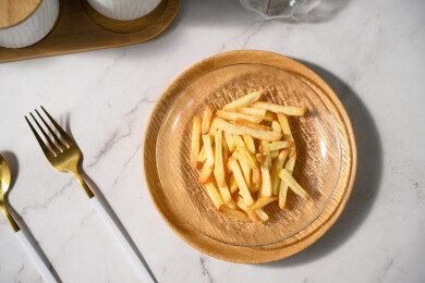 桌面上的盘子里的美味可口的薯条