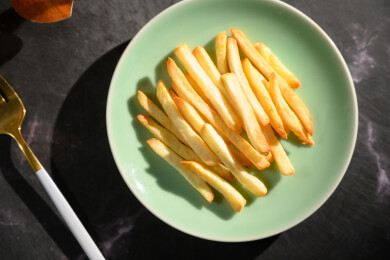 桌面上的盘子里的美味可口的薯条