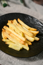 桌面上的盘子里的美味可口的薯条