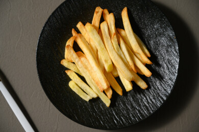 桌面上的盘子里的美味可口的薯条