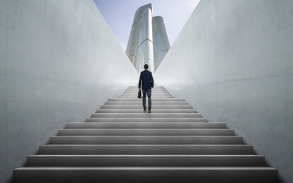 商务人士独自走上宽阔的混凝土阶梯