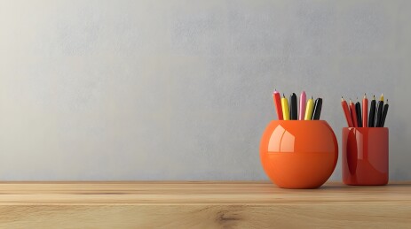 木质桌面上的陶瓷笔筒与钢笔