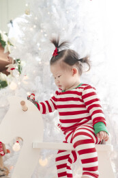 白色圣诞树前骑白木马的女幼宝宝