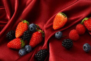 红色布背景上的新鲜莓果