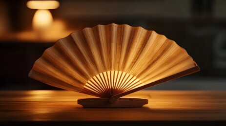 柔光下木桌上的竹扇