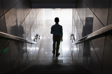 男子背影走向地铁站明亮出口