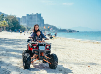 亲子在广东惠东巽寮湾沙滩上玩ATV