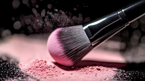 化妆刷沾取粉色粉末