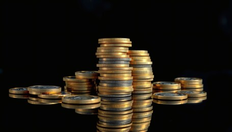 堆叠在黑色背景上的金色硬币