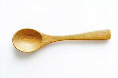 白色背景下木制勺子的高角度视图