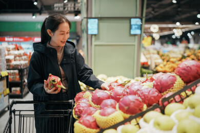 现代杂货店挑选新鲜水果的女人