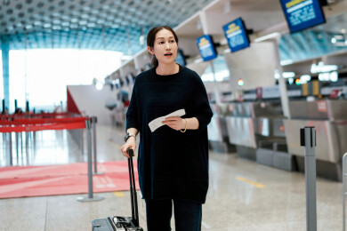现代旅客在机场航站楼携带行李和机票