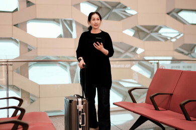 带着行李站在现代机场休息室的时尚旅行者