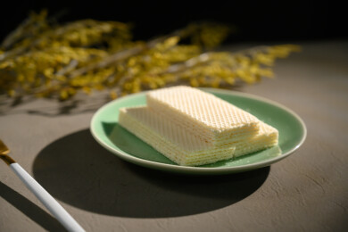 桌面上的青色陶瓷盘子里的美味可口的威化饼