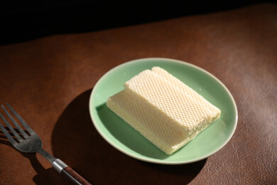 桌面上的青色陶瓷盘子里的美味可口的威化饼