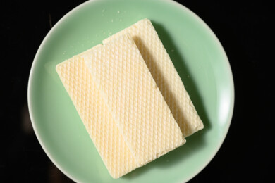 桌面上的青色陶瓷盘子里的美味可口的威化饼