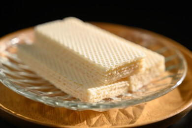 桌面上的青色陶瓷盘子里的美味可口的威化饼