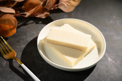 桌面上的青色陶瓷盘子里的美味可口的威化饼