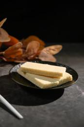 桌面上的青色陶瓷盘子里的美味可口的威化饼