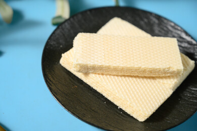 桌面上的青色陶瓷盘子里的美味可口的威化饼