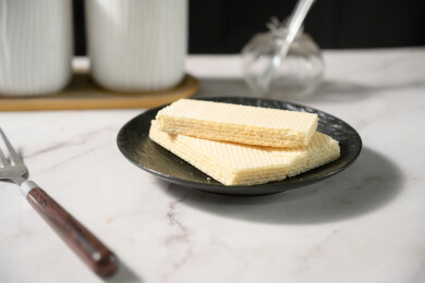 桌面上的青色陶瓷盘子里的美味可口的威化饼