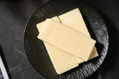 桌面上的青色陶瓷盘子里的美味可口的威化饼