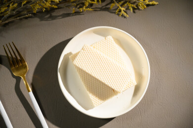 桌面上的青色陶瓷盘子里的美味可口的威化饼