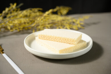 桌面上的青色陶瓷盘子里的美味可口的威化饼