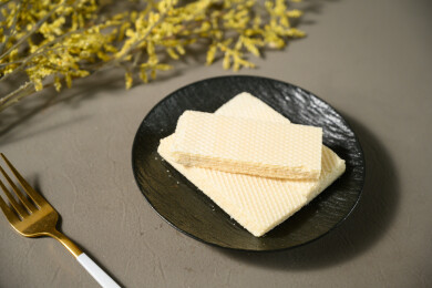 桌面上的青色陶瓷盘子里的美味可口的威化饼