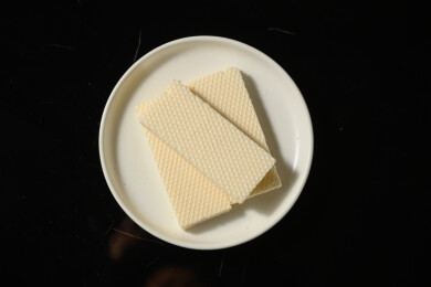 桌面上的青色陶瓷盘子里的美味可口的威化饼