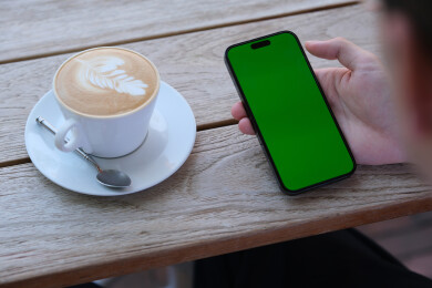 手拿着绿色屏幕的智能手机