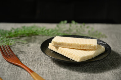 桌面上的青色陶瓷盘子里的美味可口的威化饼