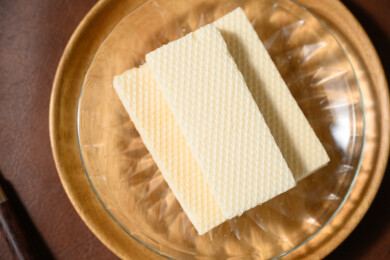 桌面上的青色陶瓷盘子里的美味可口的威化饼