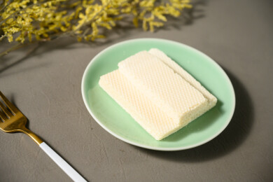 桌面上的青色陶瓷盘子里的美味可口的威化饼