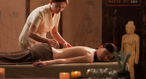 一位亚裔青年女士在做针灸治疗