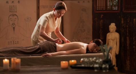 一位亚裔青年女士在做针灸治疗