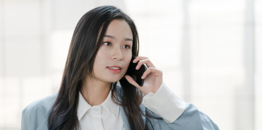 长发美女在使用手机打电活