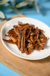 桌面上的盘子里的美味可口的香辣小鱼