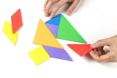 双手拼七巧板房子拼图建设家园寓意