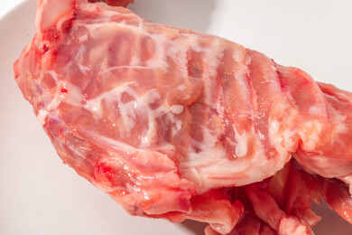 白色桌面上有一份新鲜兔排