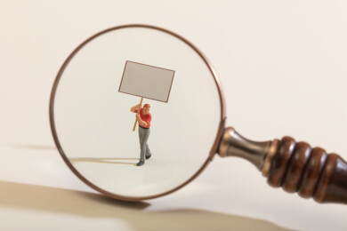 微缩创意放大镜下的人举着空白牌子