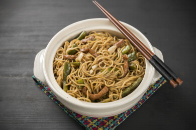 一盘豆角焖面摆放在桌面上特写