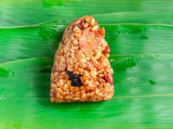 放置在粽叶上的燕麦米蛋黄粽